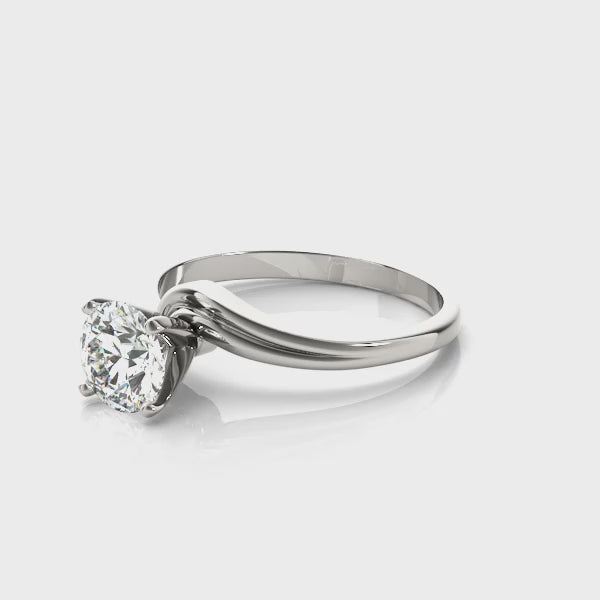 Load video: Twisting strands of precious metal flow together like an afternoon breeze and create an airy, elegant feel in this claw prong solitaire ring.